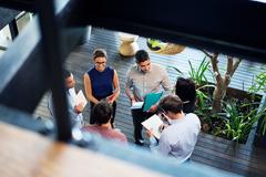 view from above of 5 coworkers standing in a circle talking
