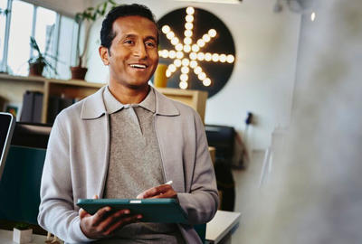man smiling holding tablet