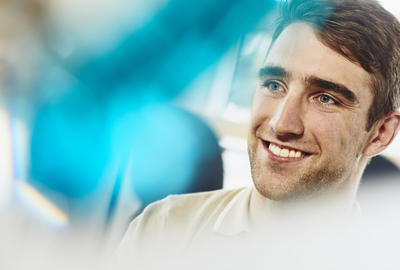 Close up - smiling man looking away.