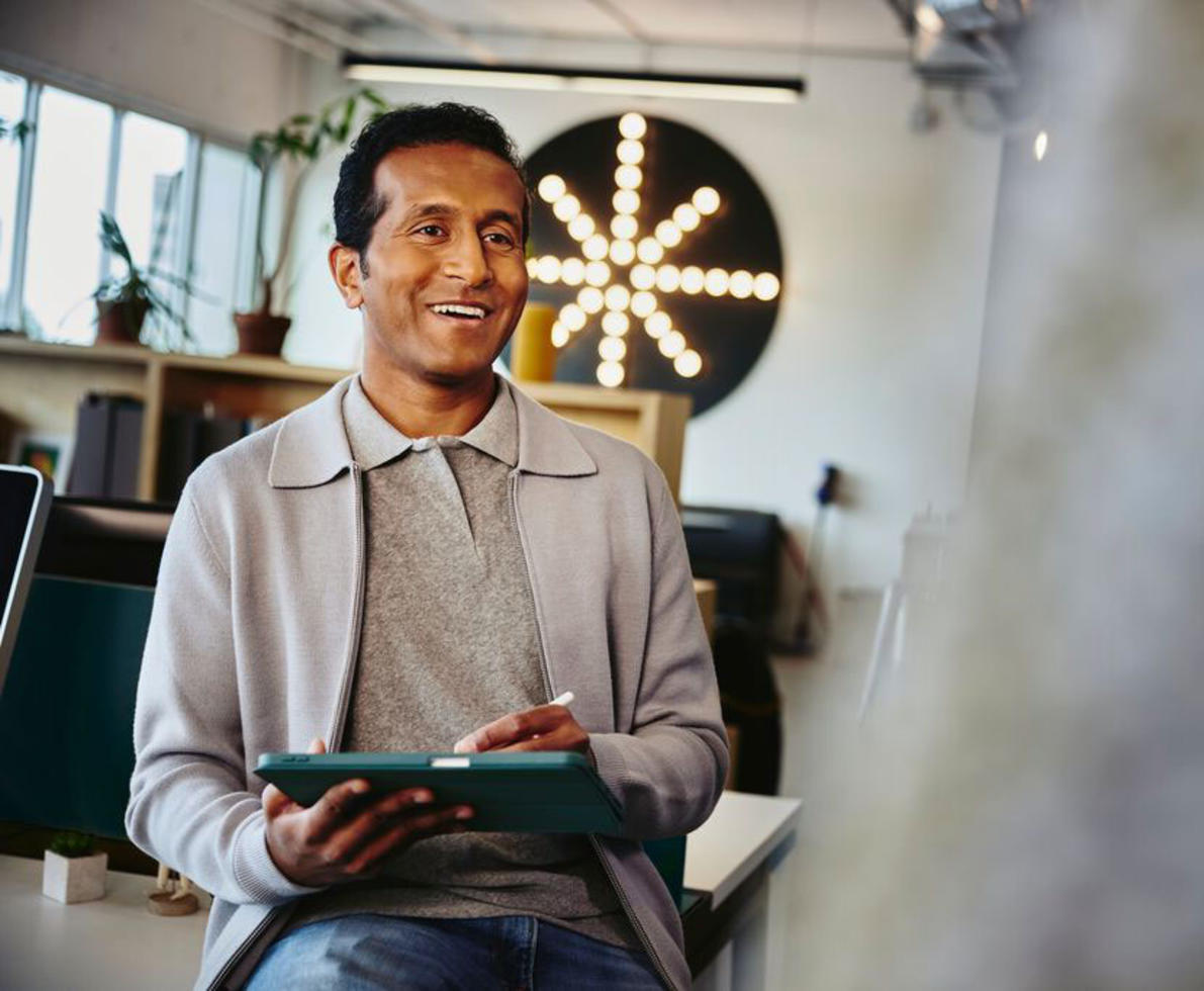 man smiling holding tablet